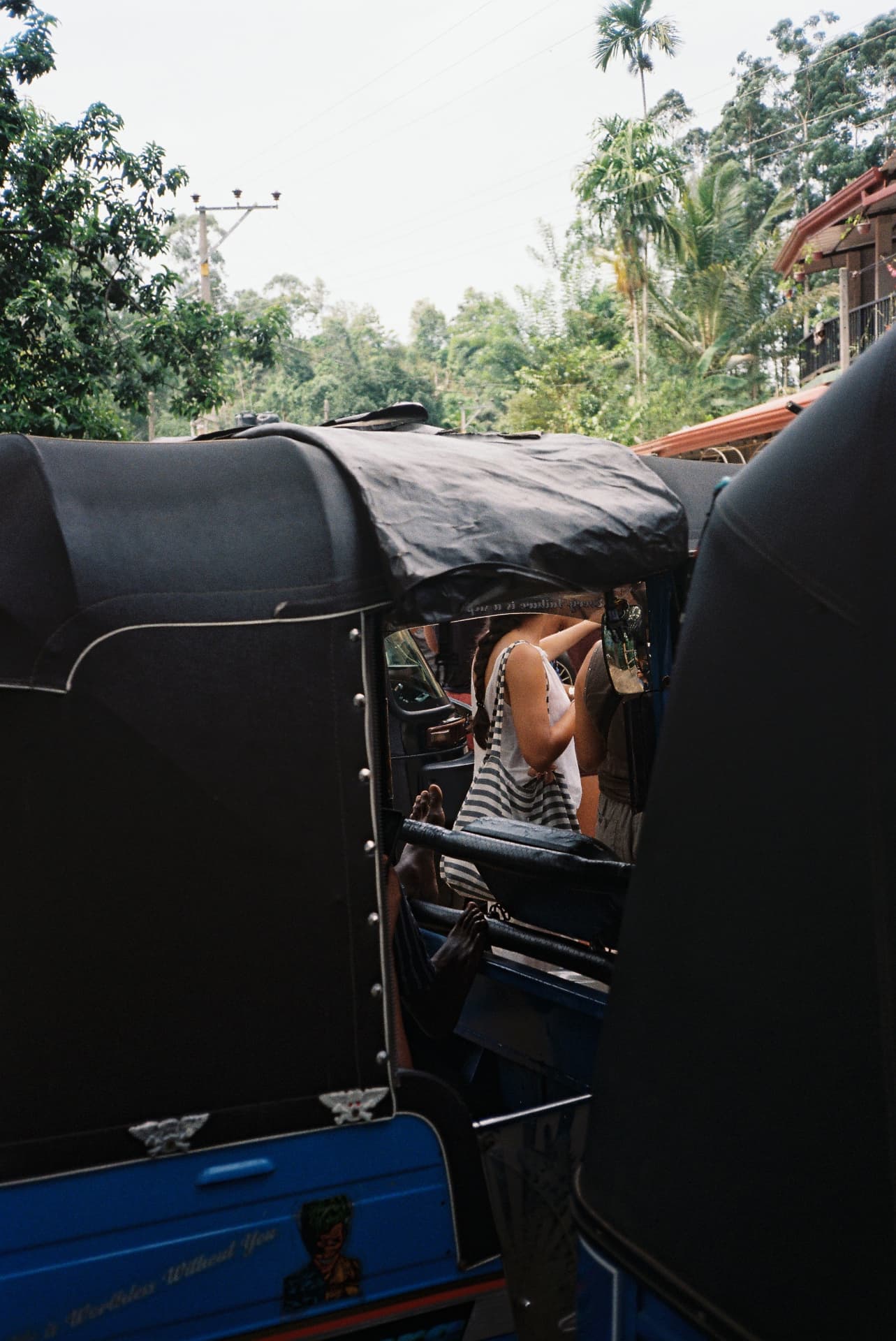 Tuk-tuks parked bumper to bumper on a jungle road