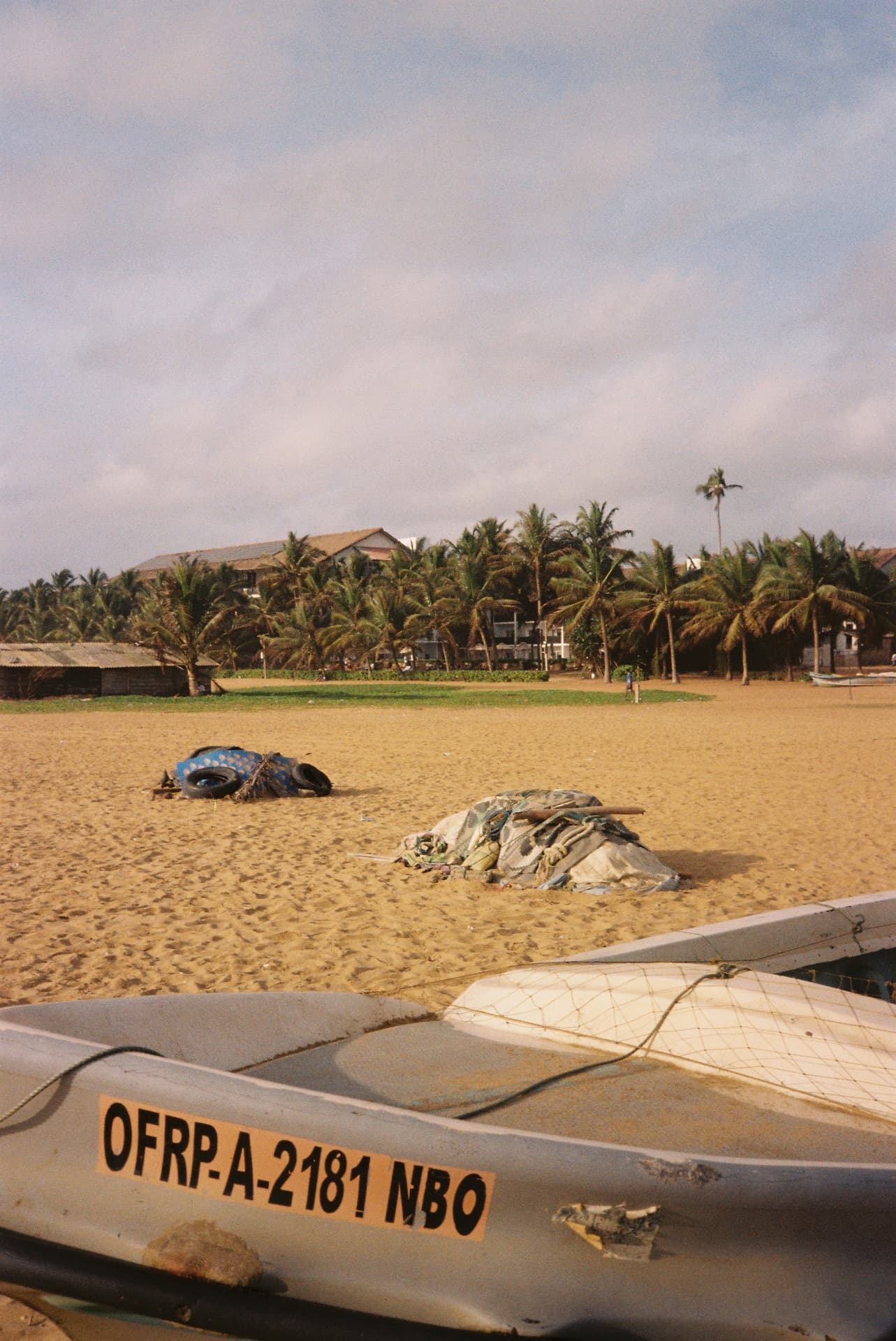 Fishing boat hull marked OFRP-A-2181 on golden sand